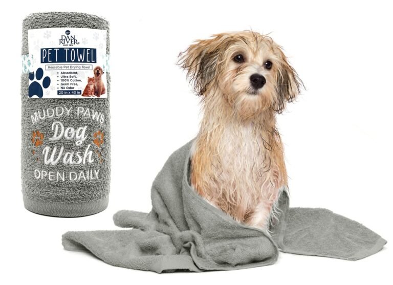 Wet dog wrapped in a gray towel next to a "Muddy Paws Dog Wash" towel