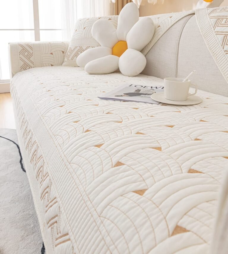 White quilted sofa with flower pillow, magazine, and teacup
